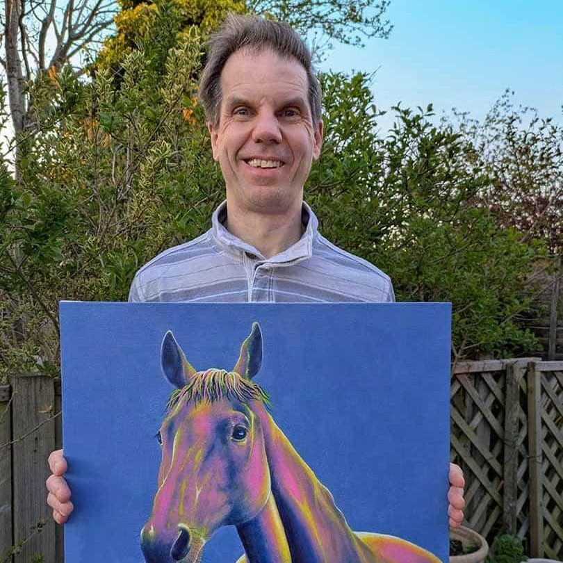 Animal portrait artist, Charles, holding his horse painting